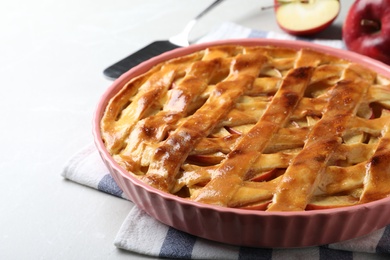 Photo of Traditional apple pie on light grey table, closeup