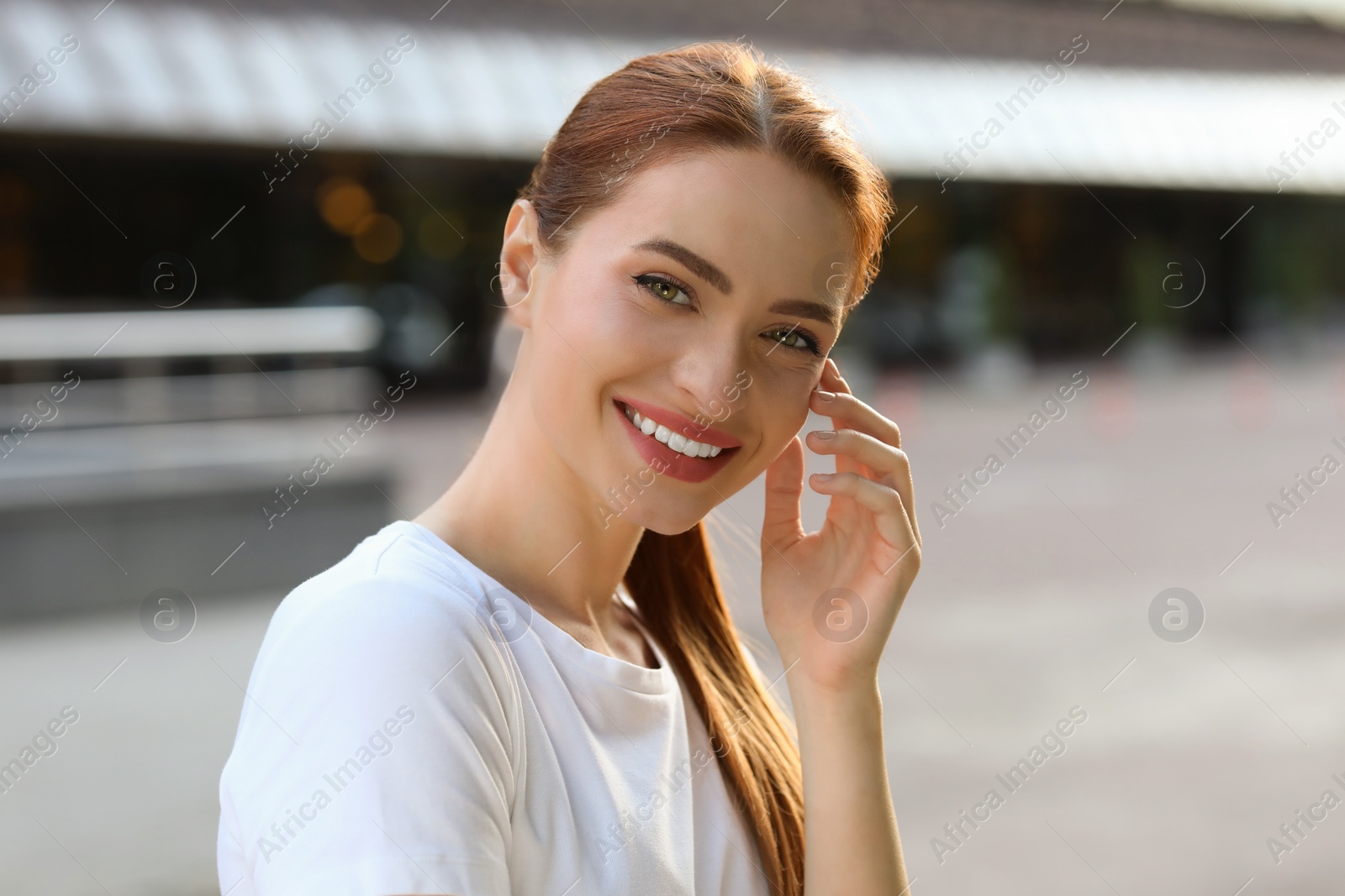 Photo of Portrait of happy young woman in casual clothes outdoors. Attractive lady smiling and looking into camera