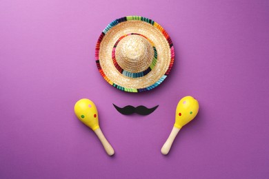 Mexican sombrero hat, fake mustache and maracas on purple background, flat lay