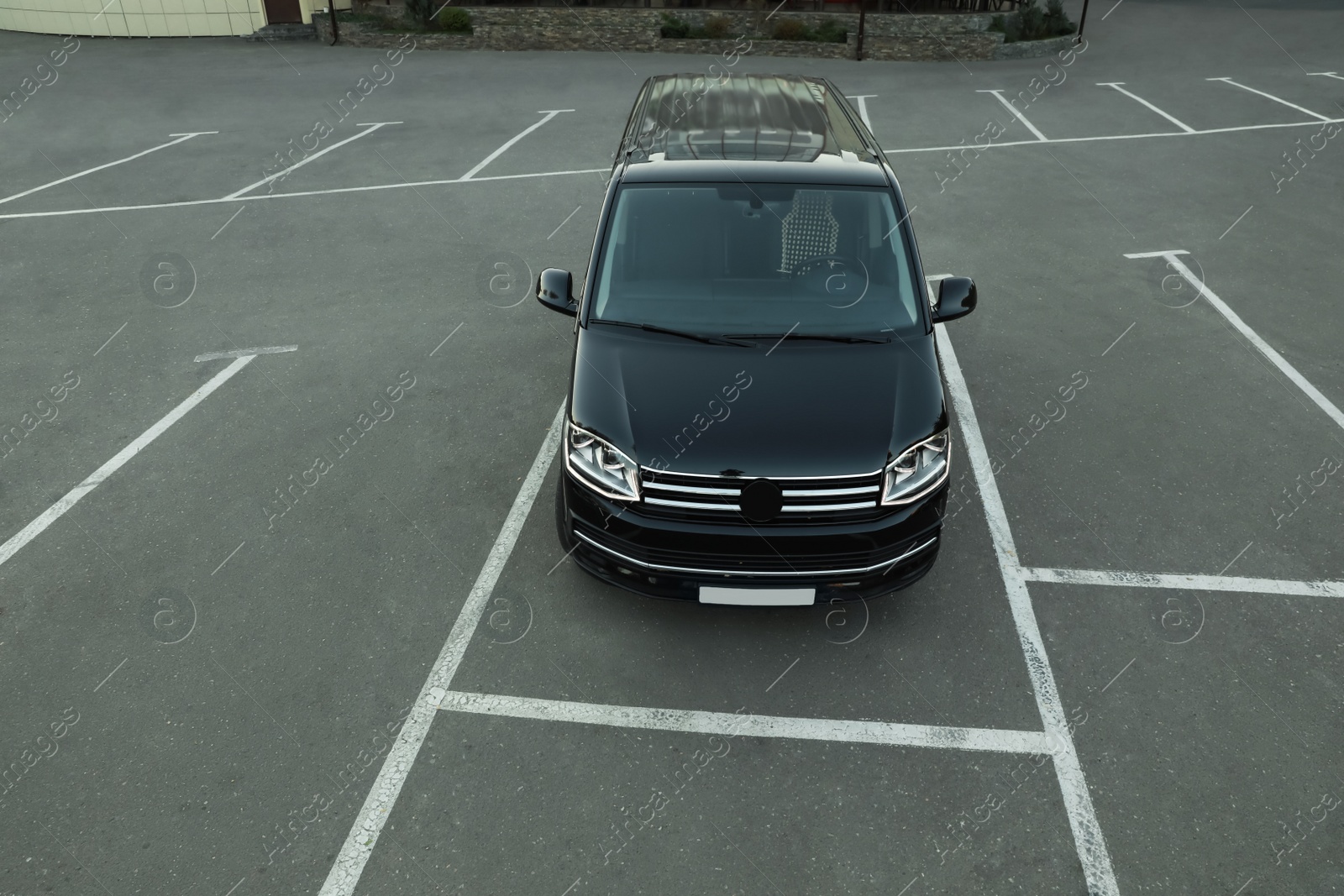 Photo of Black van on parking lot outdoors in morning