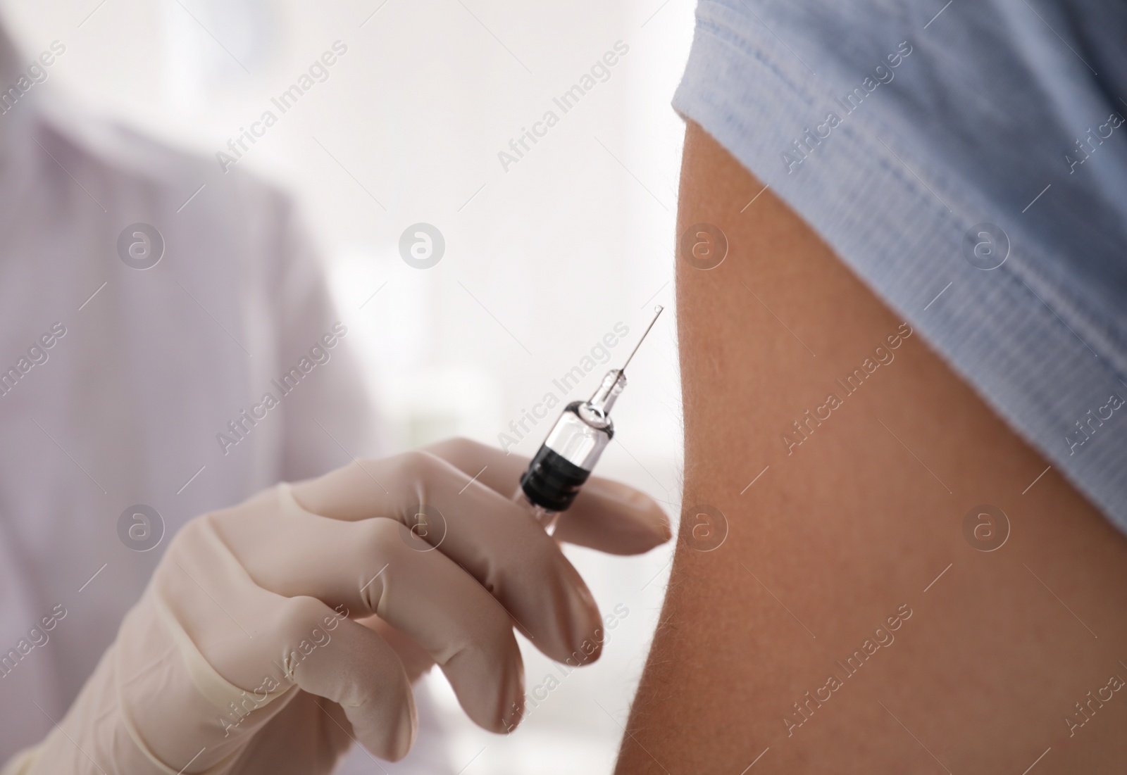 Photo of Doctor vaccinating man against Covid-19 in clinic, closeup