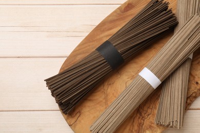 Uncooked buckwheat noodles (soba) on light wooden table, top view