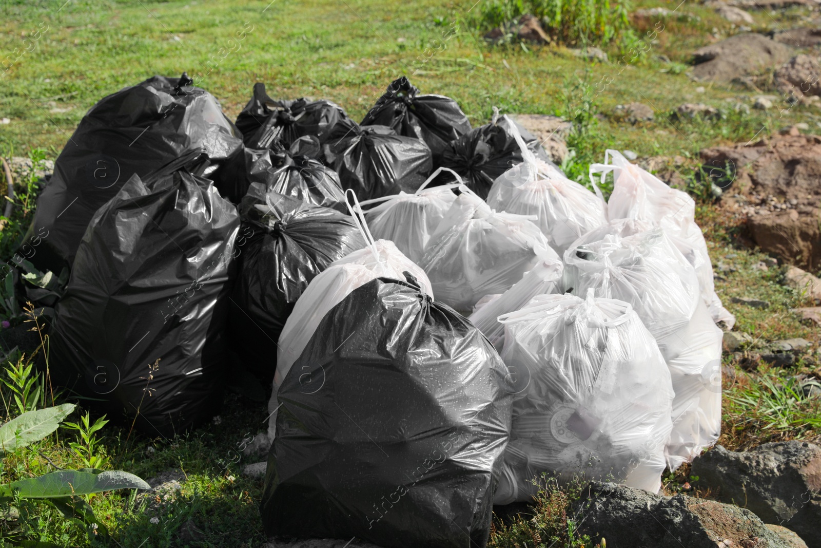 Photo of Many trash bags full of garbage outdoors. Environmental Pollution concept