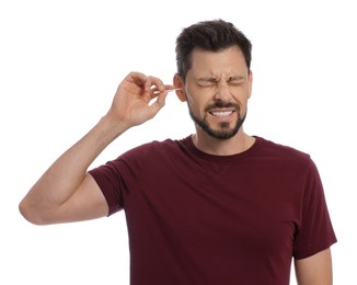 Photo of Man cleaning ears and suffering from pain on white background