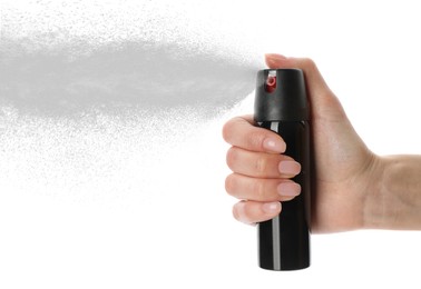 Woman using pepper spray on white background, closeup