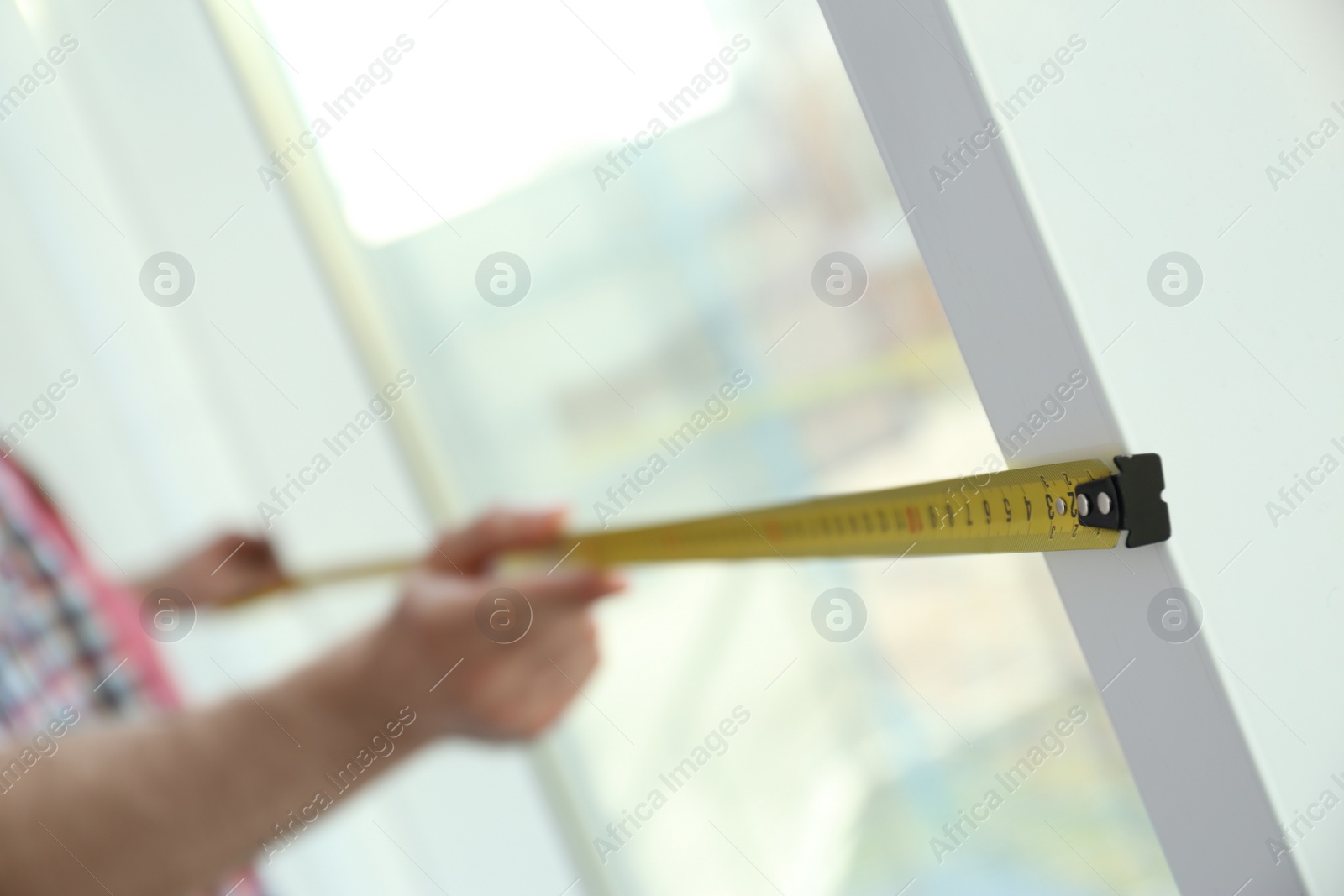 Photo of Man measuring window, closeup view. Construction tool