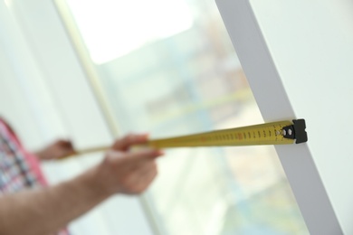 Man measuring window, closeup view. Construction tool