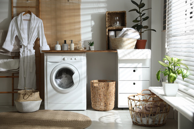 Stylish bathroom interior with modern washing machine