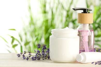 Photo of Different hand care cosmetic products and lavender flowers on white wooden table, space for text