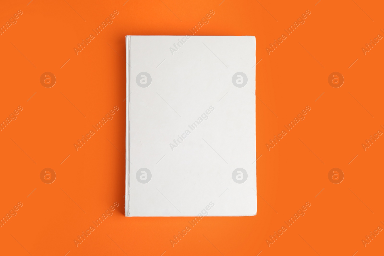 Photo of Book with blank cover on orange background, top view