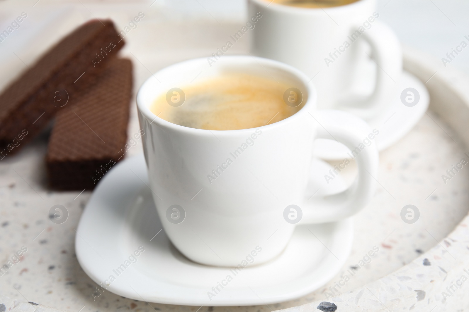 Photo of Delicious coffee and wafers for breakfast on tray, closeup
