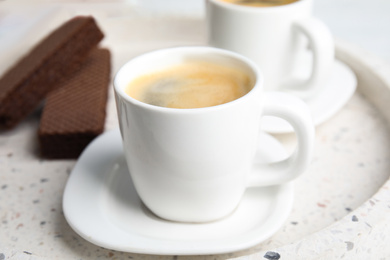 Delicious coffee and wafers for breakfast on tray, closeup