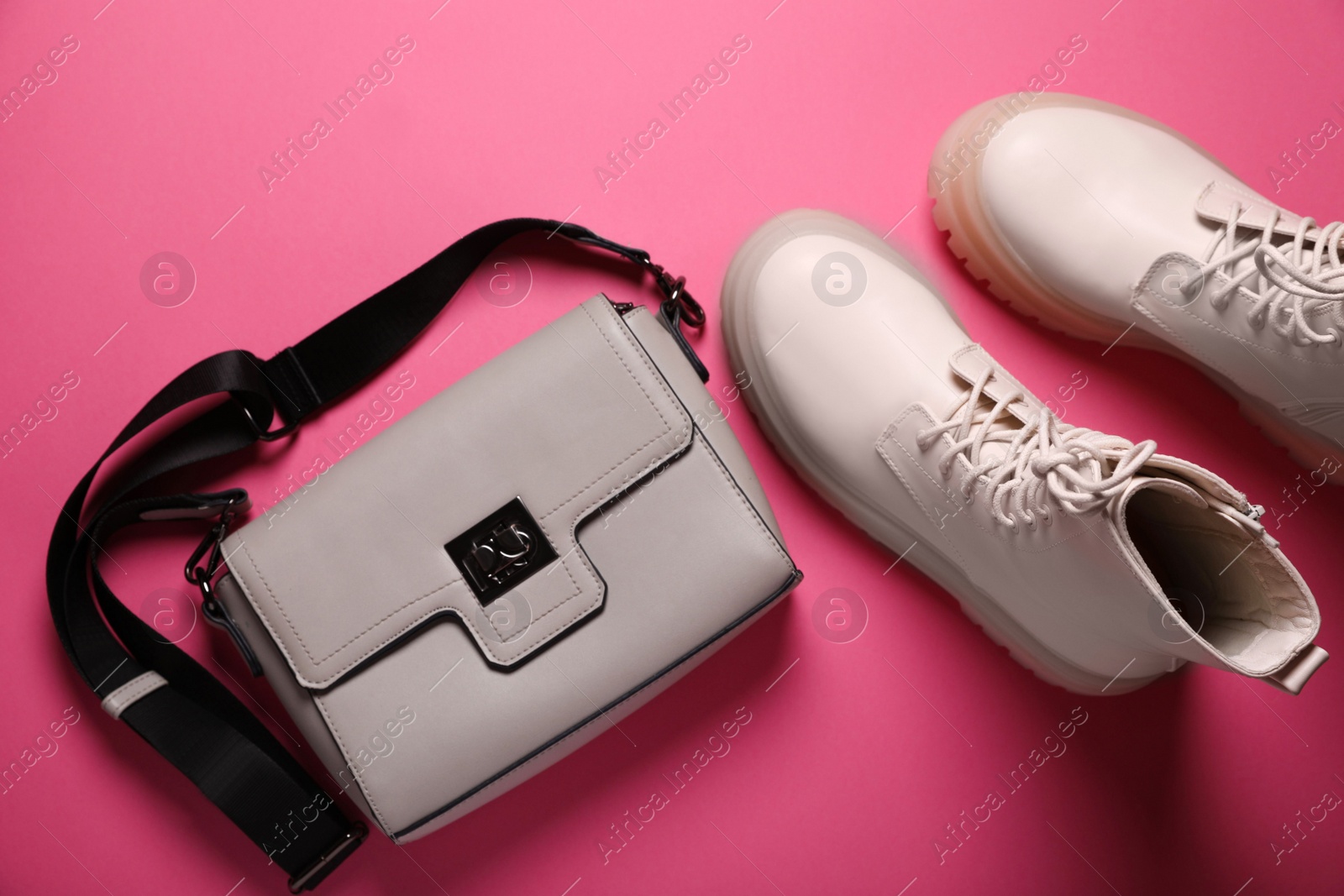 Photo of Pair of stylish leather shoes and bag on pink background, flat lay