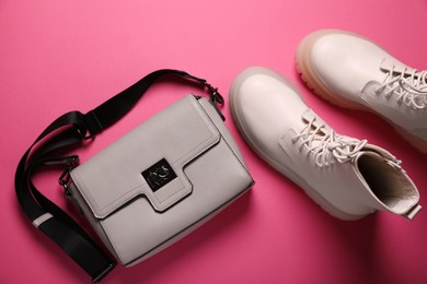 Photo of Pair of stylish leather shoes and bag on pink background, flat lay