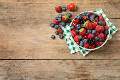 Photo of Mix of ripe berries on wooden table, flat lay. Space for text