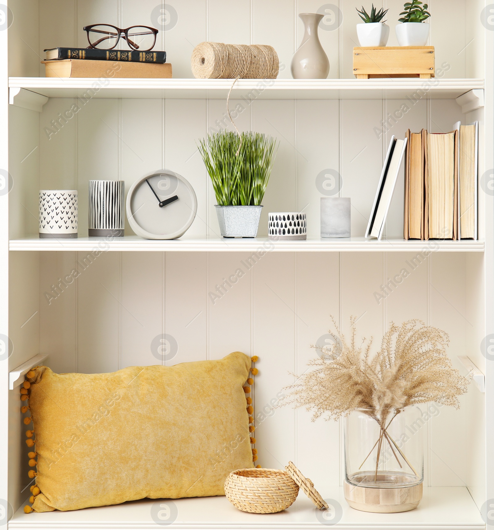 Photo of White shelving unit with plants and different decorative stuff