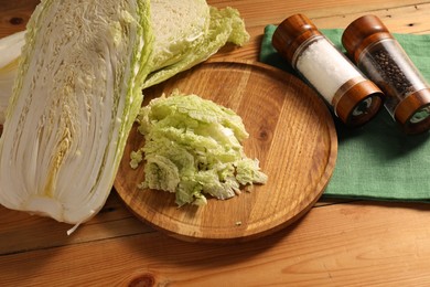 Photo of Fresh Chinese cabbage and spices on wooden table