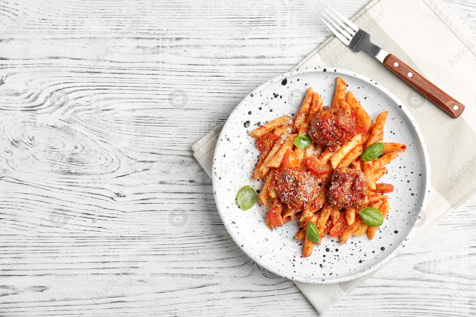 Photo of Delicious pasta with meatballs and tomato sauce on wooden background