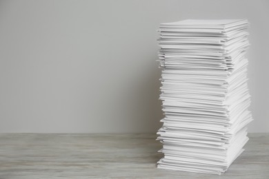 Photo of Stack of paper sheets on wooden table. Space for text