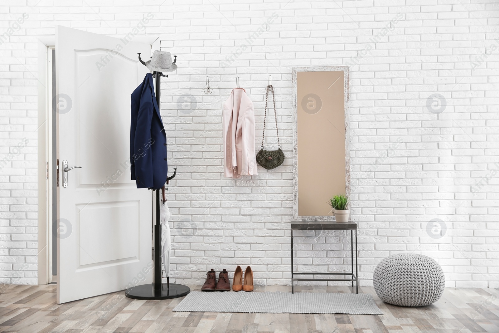 Photo of Stylish hallway interior with door and comfortable furniture