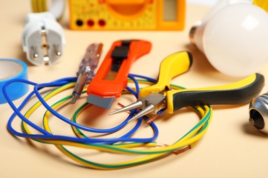 Set of electrician's tools on color background