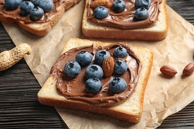 Photo of Toast bread with chocolate spread and blueberry on dark background, closeup