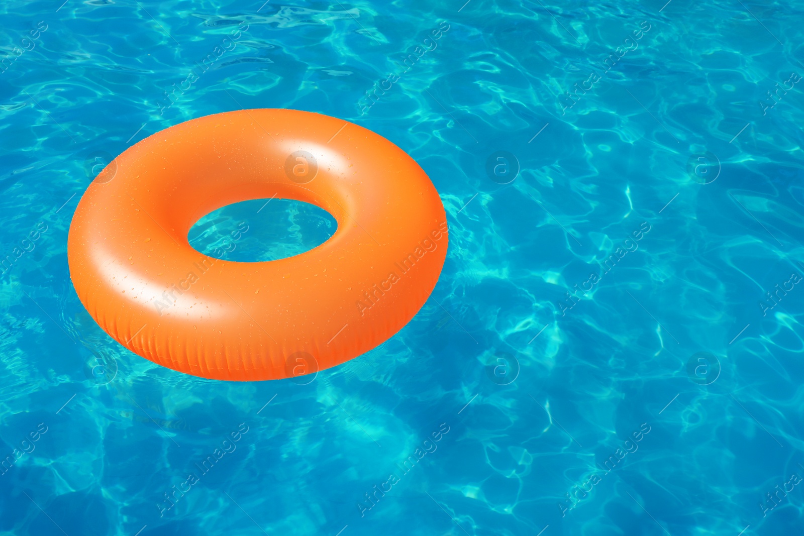 Photo of Inflatable ring floating in swimming pool on sunny day. Space for text