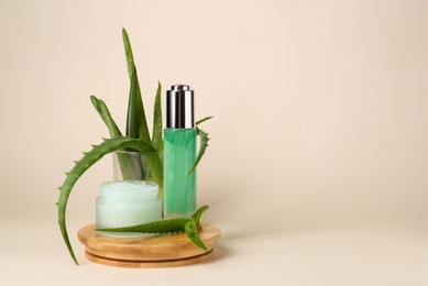 Photo of Cosmetic products and fresh aloe on beige background, space for text