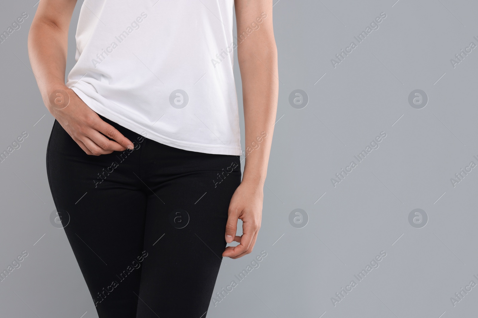 Photo of Woman wearing stylish black jeans on light gray background, closeup. Space for text