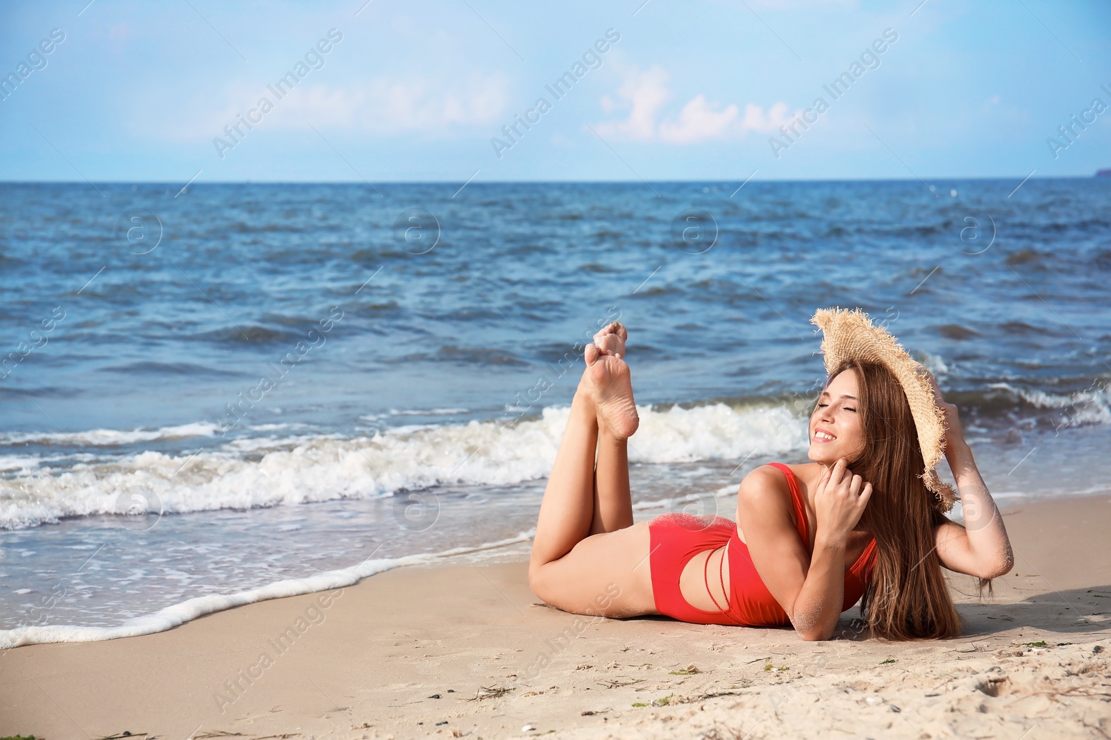 Photo of Attractive young woman in beautiful one-piece swimsuit on beach