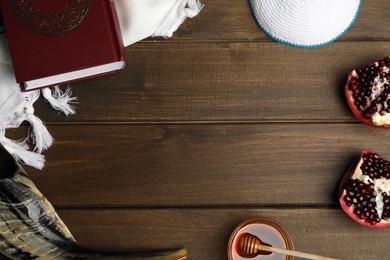 Photo of Frame of Rosh Hashanah holiday symbols on wooden table, flat lay. Space for text