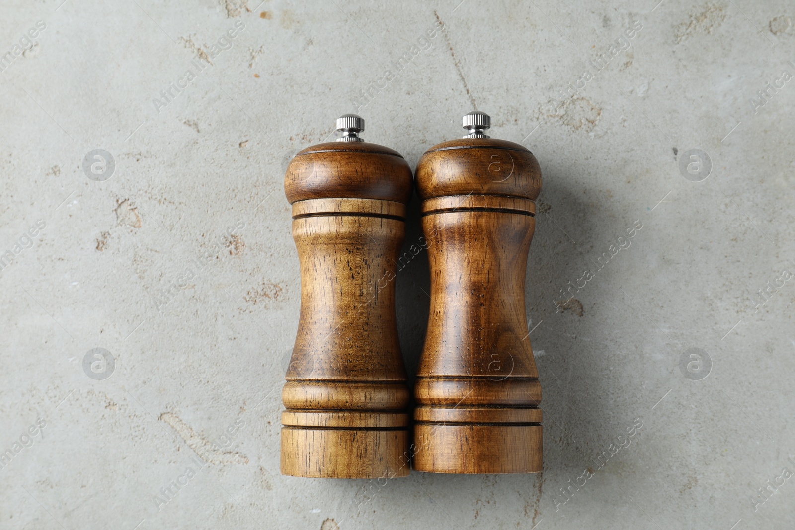 Photo of Wooden salt and pepper shakers on light textured table, top view