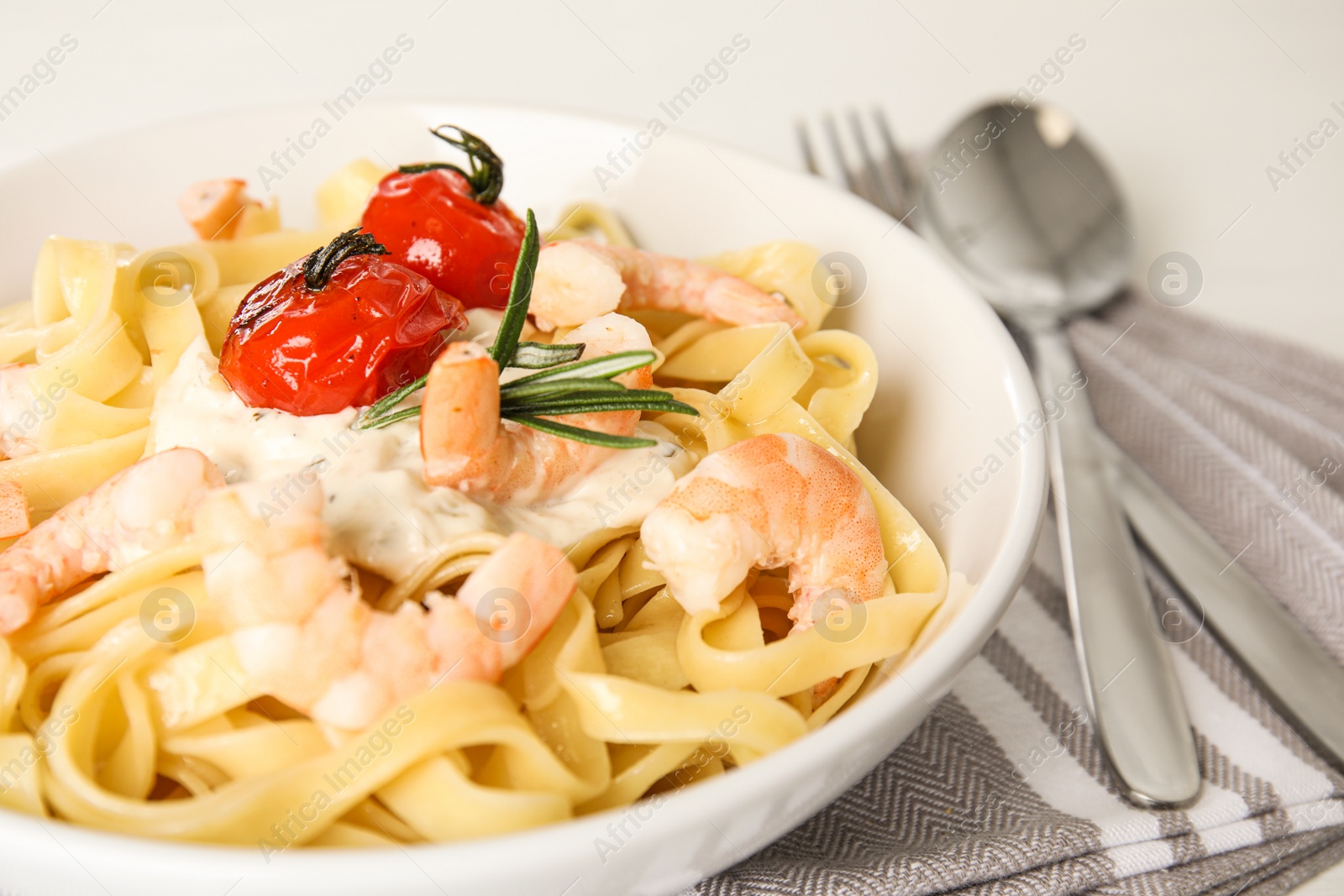 Photo of Delicious pasta with shrimps served on table, closeup