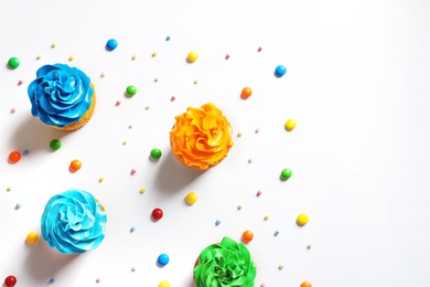 Photo of Flat lay composition with colorful birthday cupcakes on light background