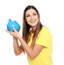 Young woman with piggy bank on white background