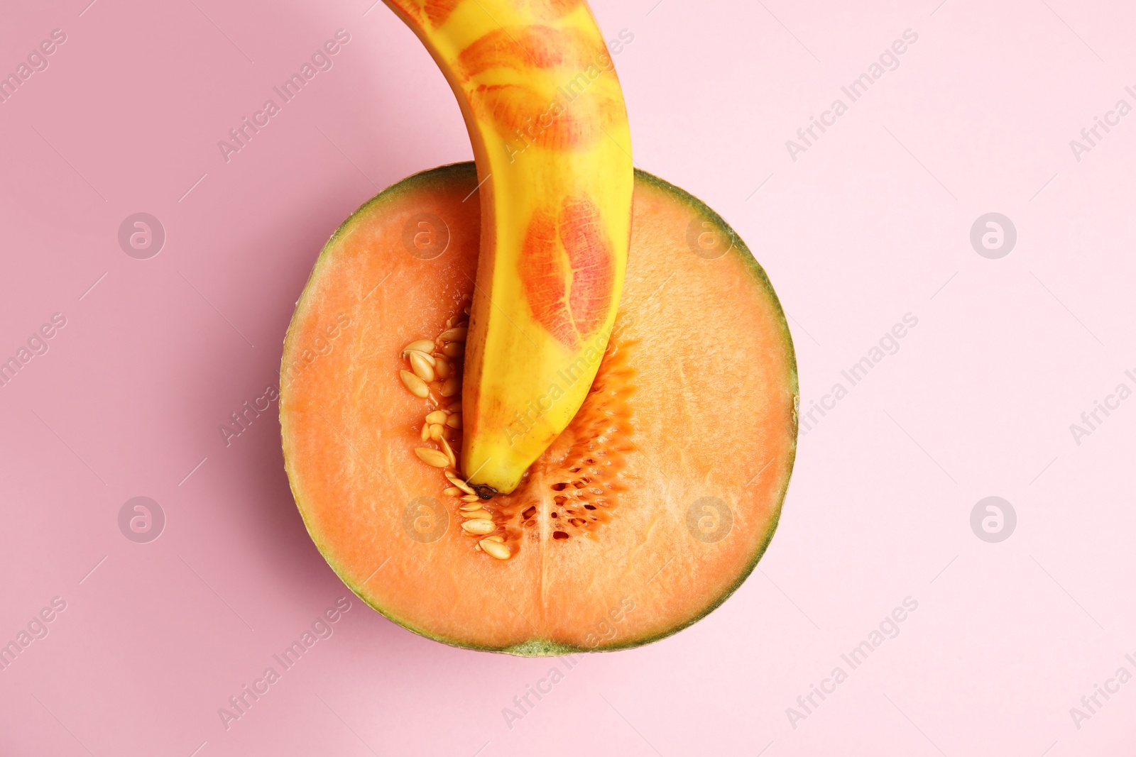 Photo of Flat lay composition with fresh banana and melon on pink background. Sex concept