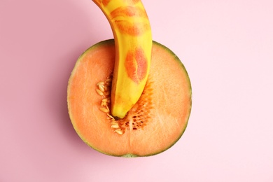 Photo of Flat lay composition with fresh banana and melon on pink background. Sex concept