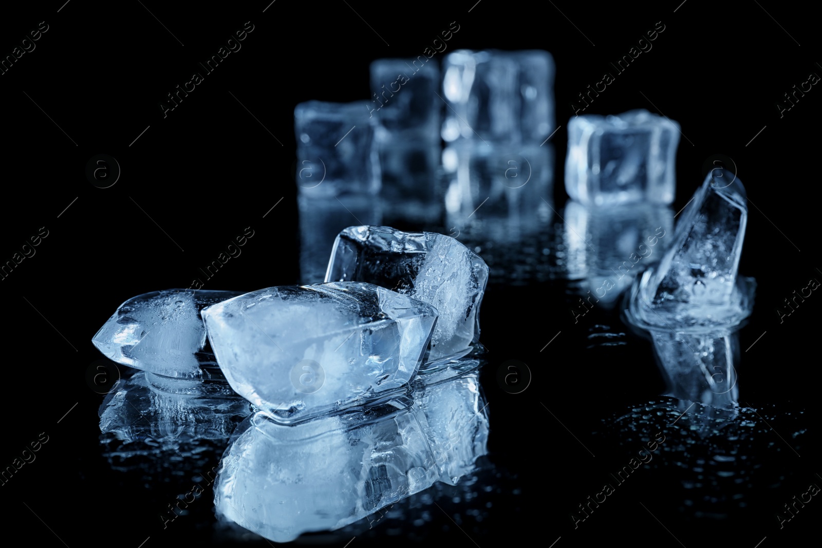 Photo of Ice cubes on black mirror surface. Space for text