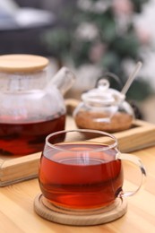 Cup of aromatic tea on wooden table indoors