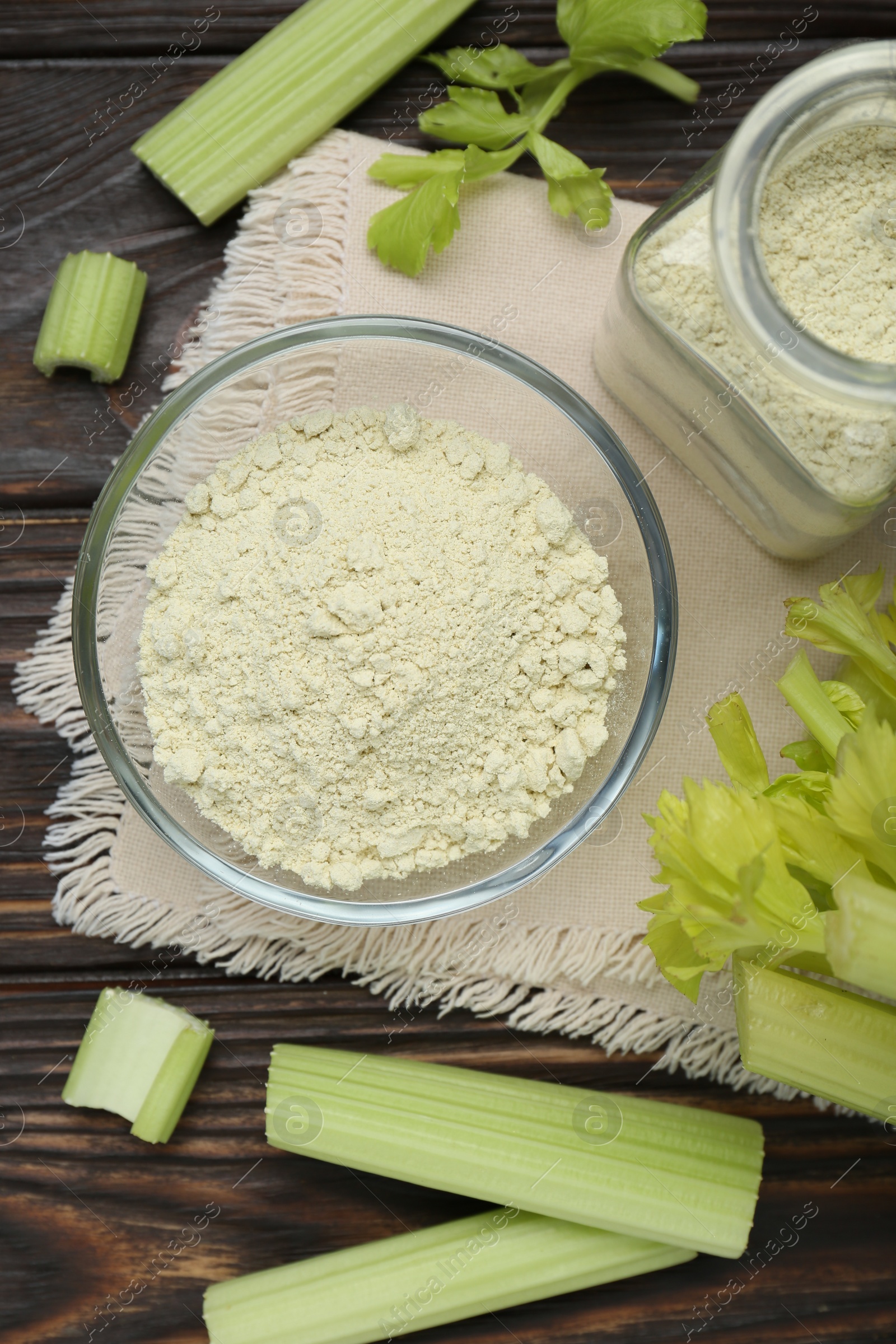 Photo of Natural celery powder and fresh stalks on wooden table, flat lay