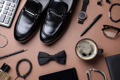 Male accessories on brown background, flat lay