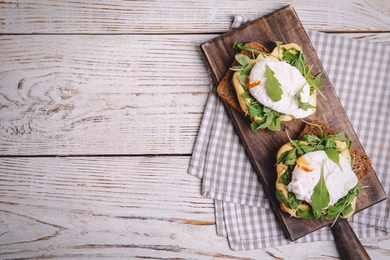 Photo of Delicious sandwiches with arugula and egg on white wooden table, top view. Space for text