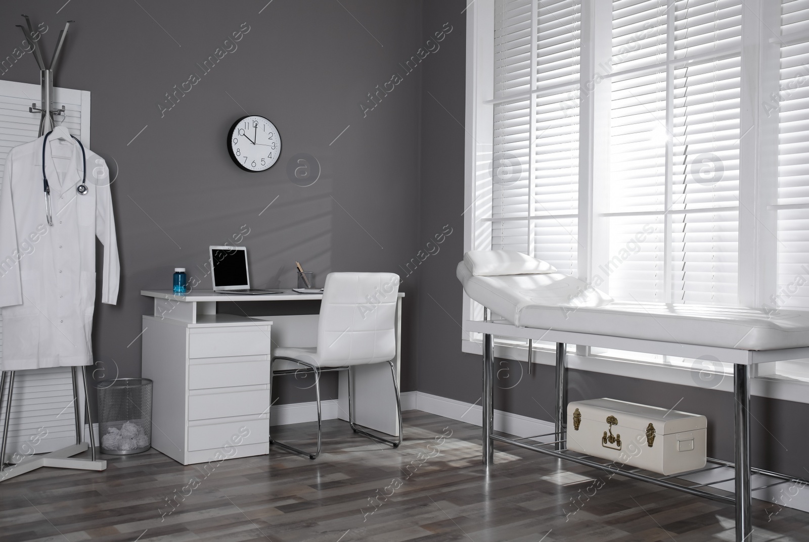 Photo of Modern medical office interior with doctor's workplace and examination table