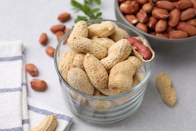 Fresh unpeeled peanuts on grey table, closeup