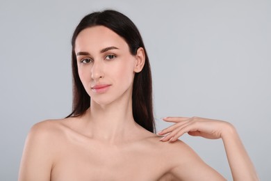 Portrait of beautiful young woman on light grey background