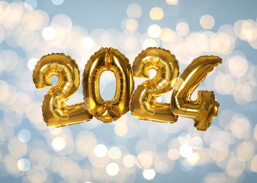 Image of New 2024 Year. Golden number shaped balloons on light blue background with blurred lights