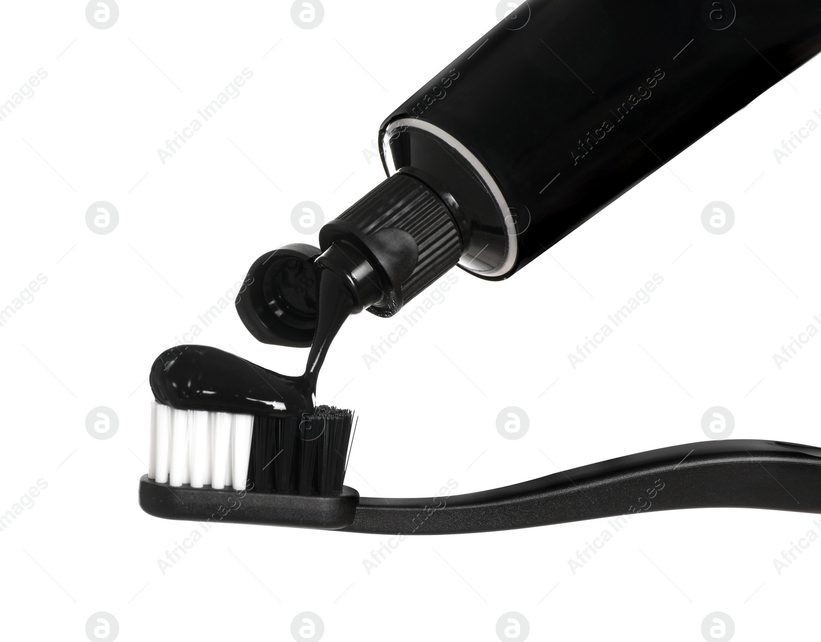 Photo of Applying charcoal toothpaste on brush against white background