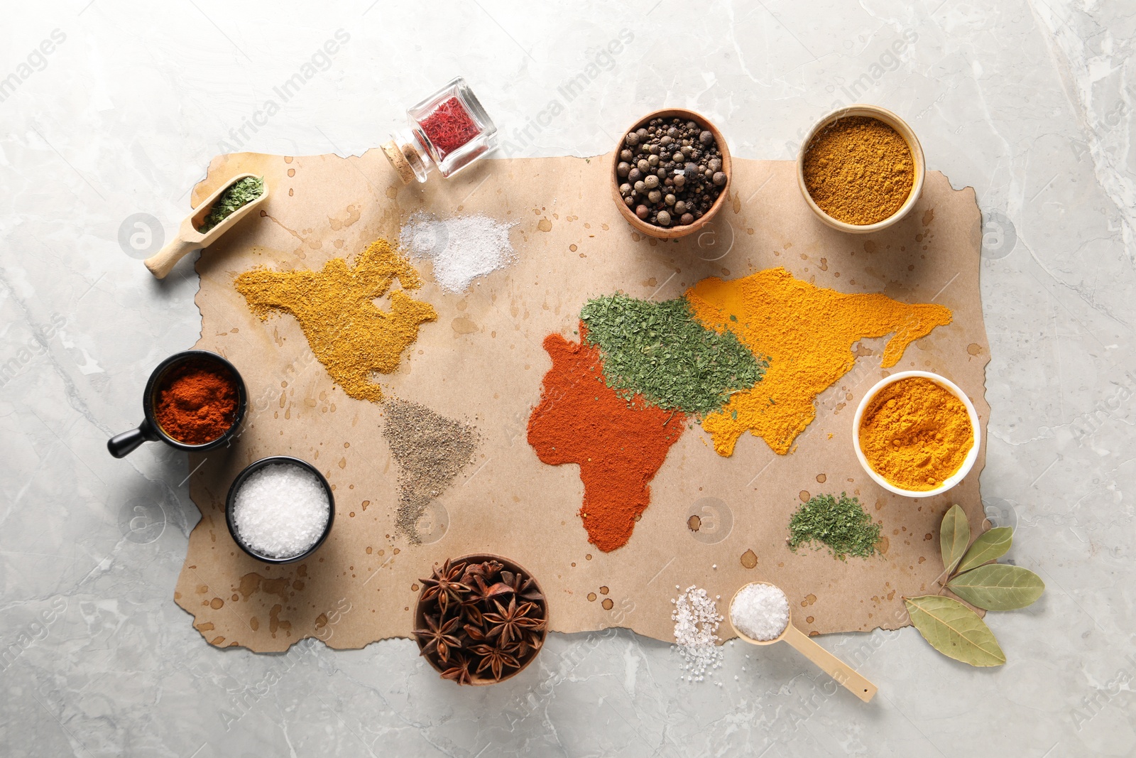 Photo of World map of different spices and products on light grey marble table, top view