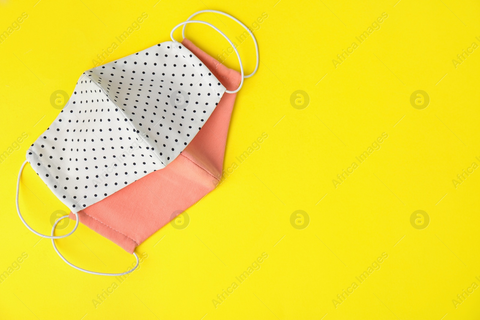 Photo of Homemade protective face masks on yellow background, flat lay. Space for text