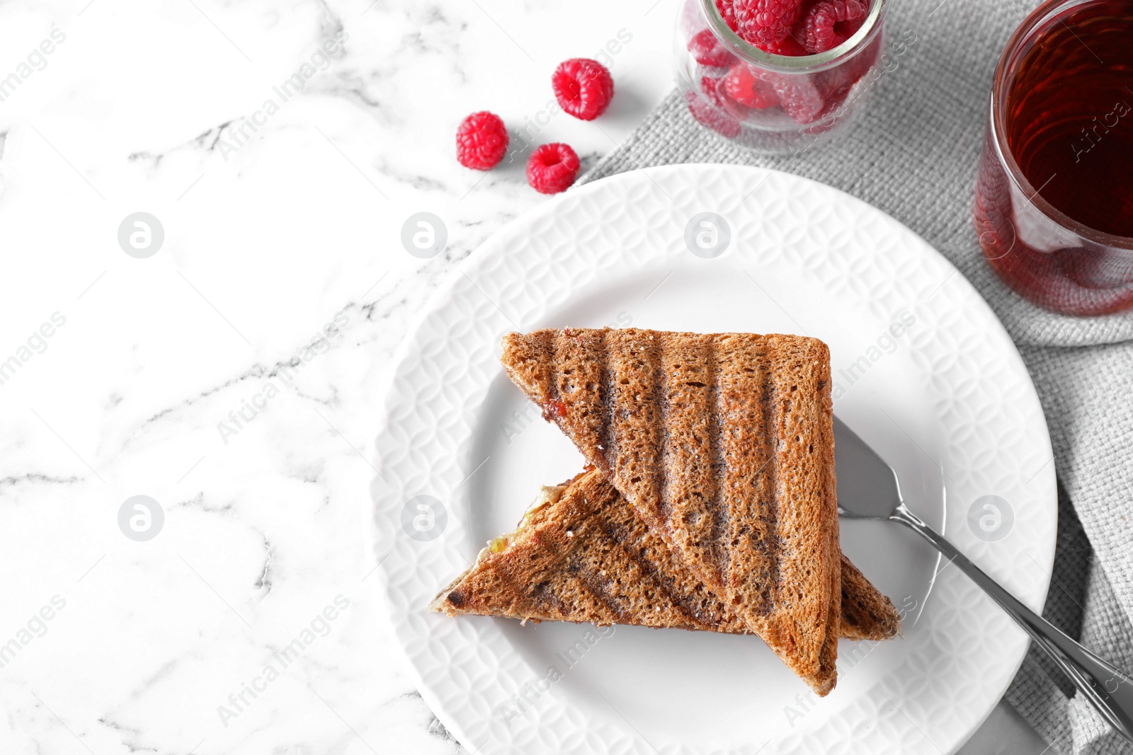 Image of Tasty sandwiches with raspberry jam for breakfast on white marble table, flat lay